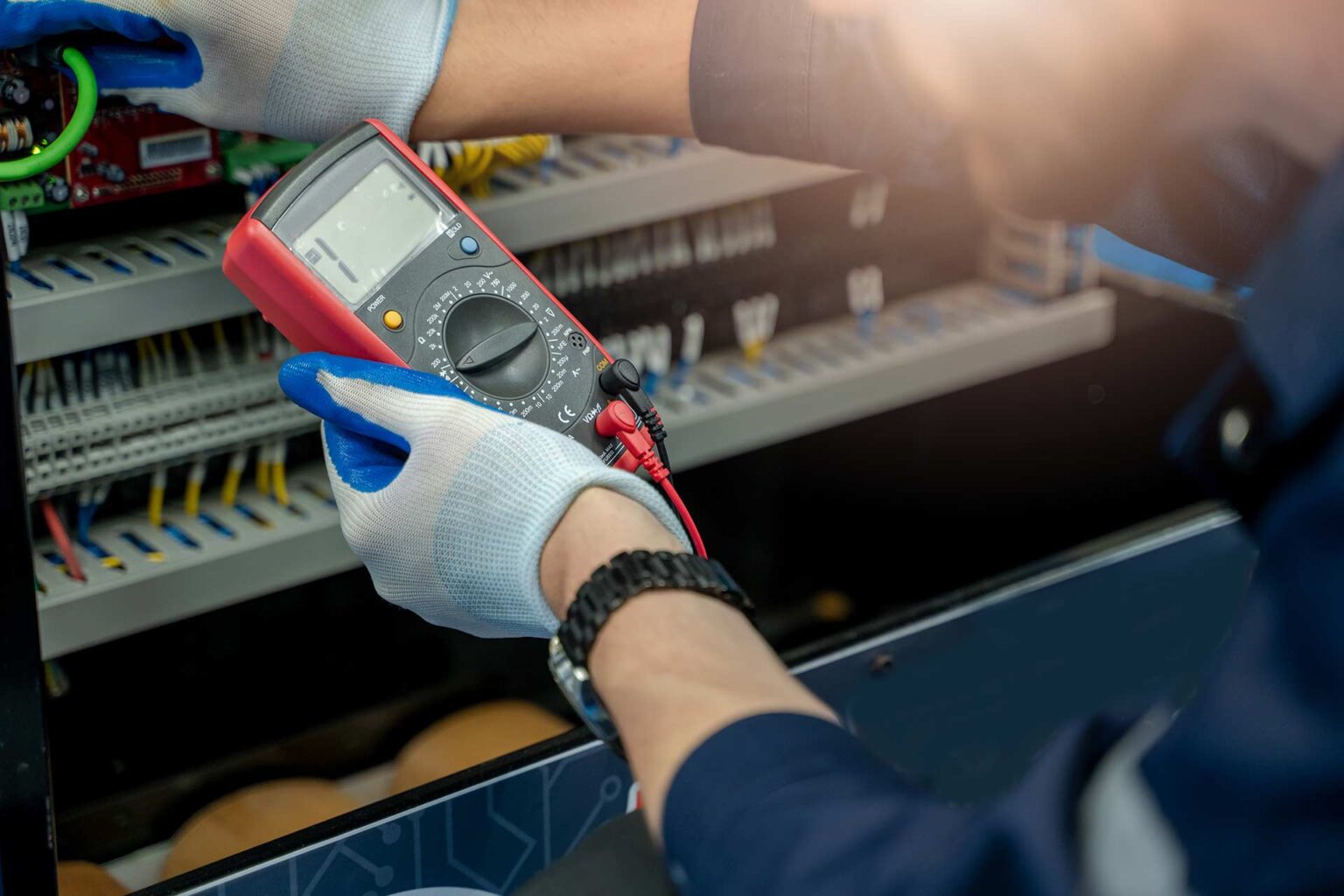 Profissional utilizando multímetro em quadro elétrico