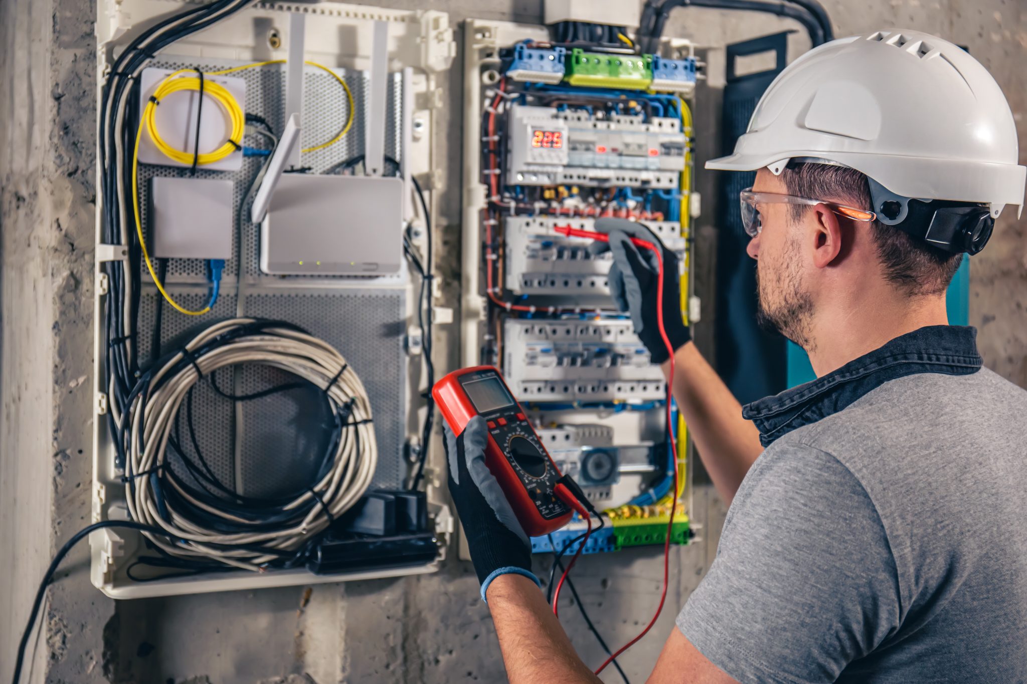 Técnico realizando manutenção em quadro de distribuição elétrica